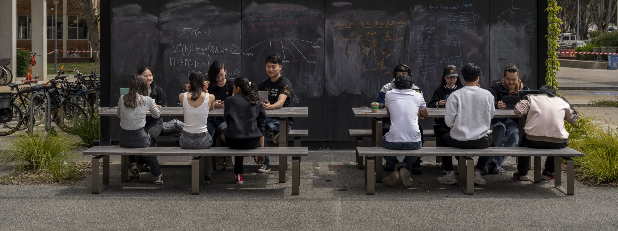 Group of students sitting in front of the black board.